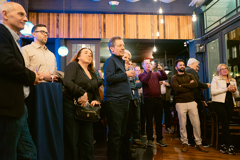 Guests gathered with drinks at Incisiv’s Happy Hour